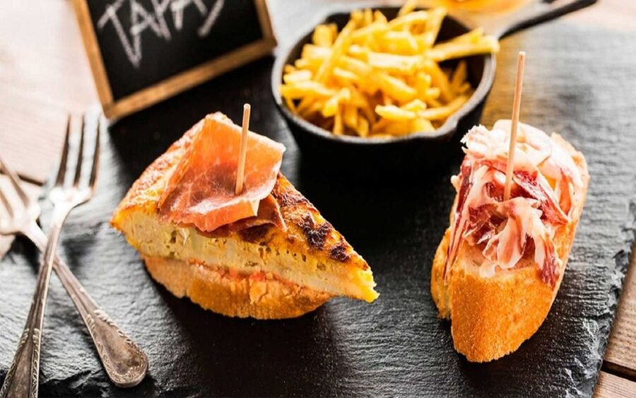 Madrid: Old Madrid Walking Food and Wine Tour - Starting beneath the red umbrella at Puerta del Sol
